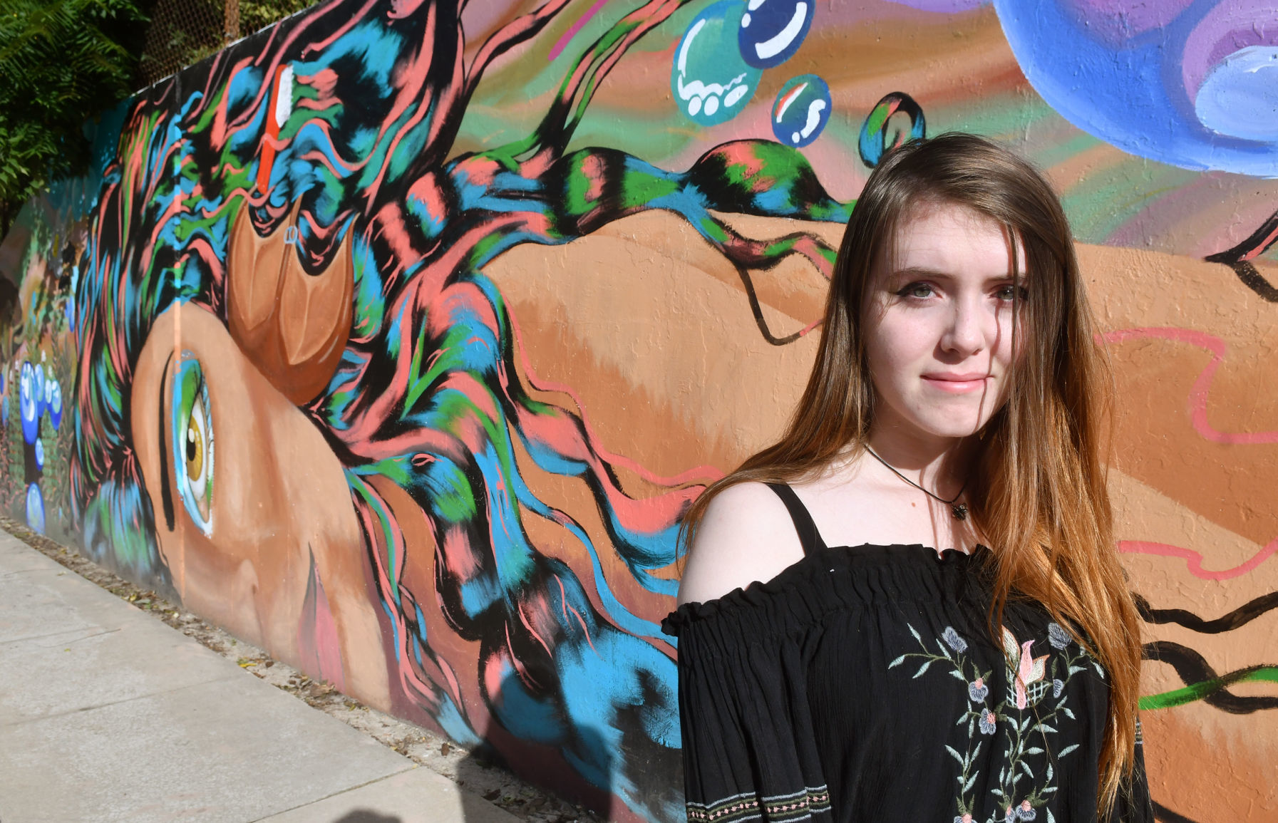 Madelynn Vogt artist of mermaid face on mural at Lincoln Road and 18th Street in Bettendorf.